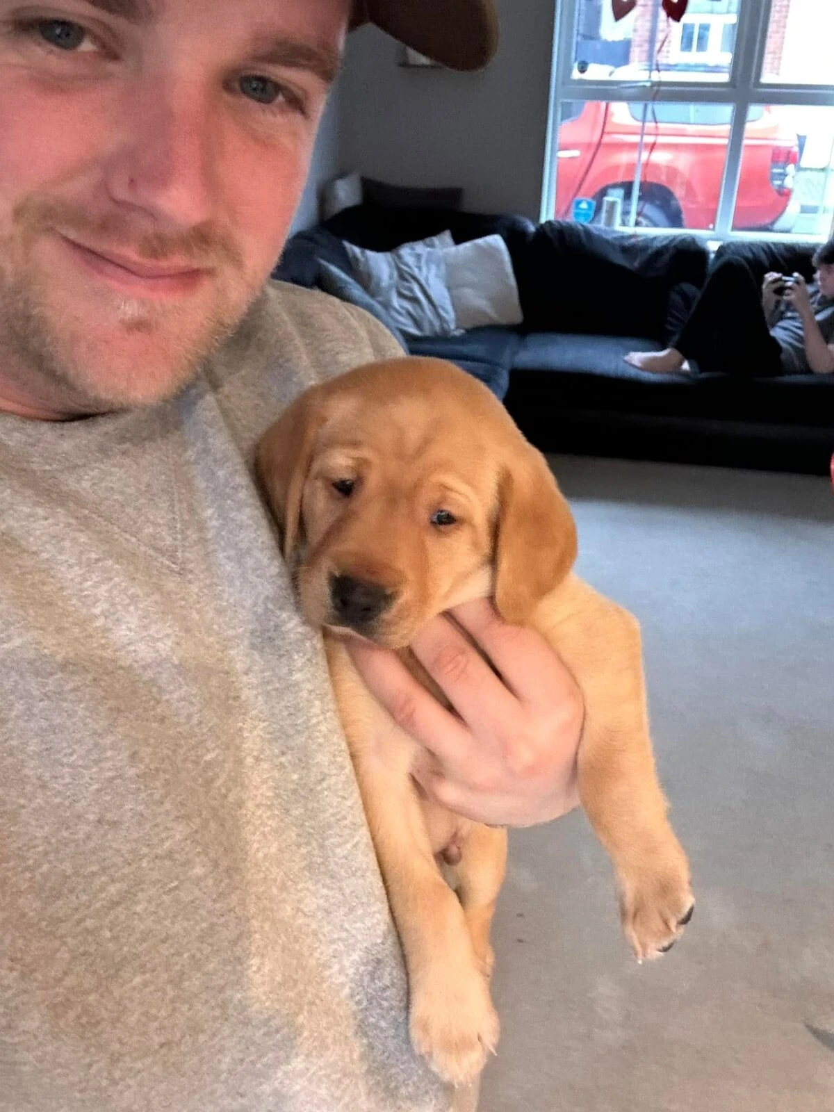 Ashley holding a fox red Labrador puppy